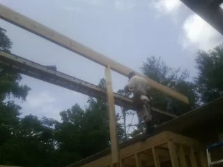 Carpenter setting a ridge beam over a new addition frame — Ice Dam Removal by Roofing Brothers in Corryton