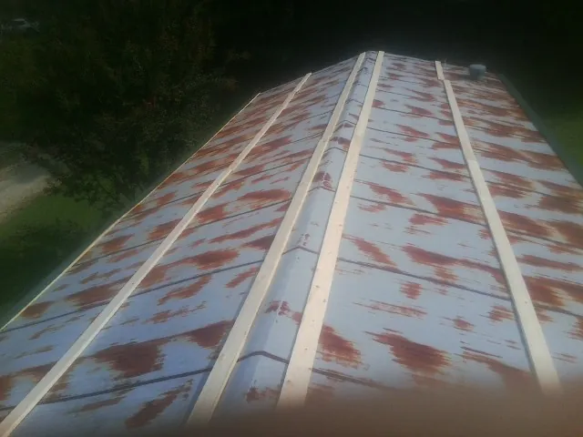 Rusted metal roof panels with new wood purlins before replacement — Storm Damage Roof Repair in Corryton by Roofing Brothers