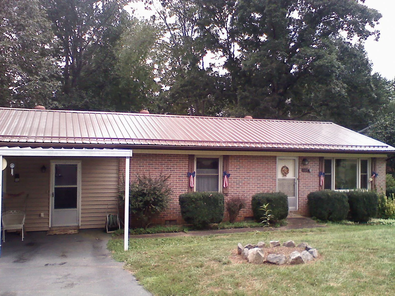 Bronze metal roof and carport on a brick ranch home — Roof Repair work by our crew in Corryton